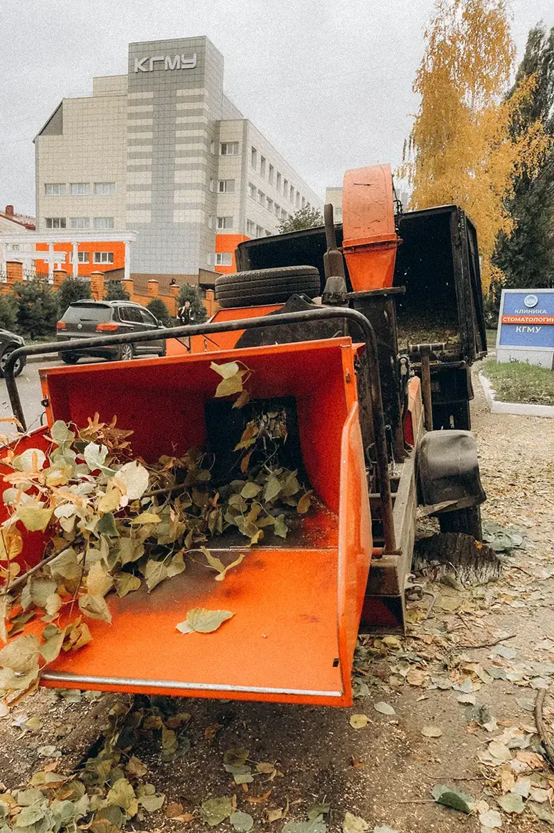 Измельчитель древесины на фоне здания КГМУ
